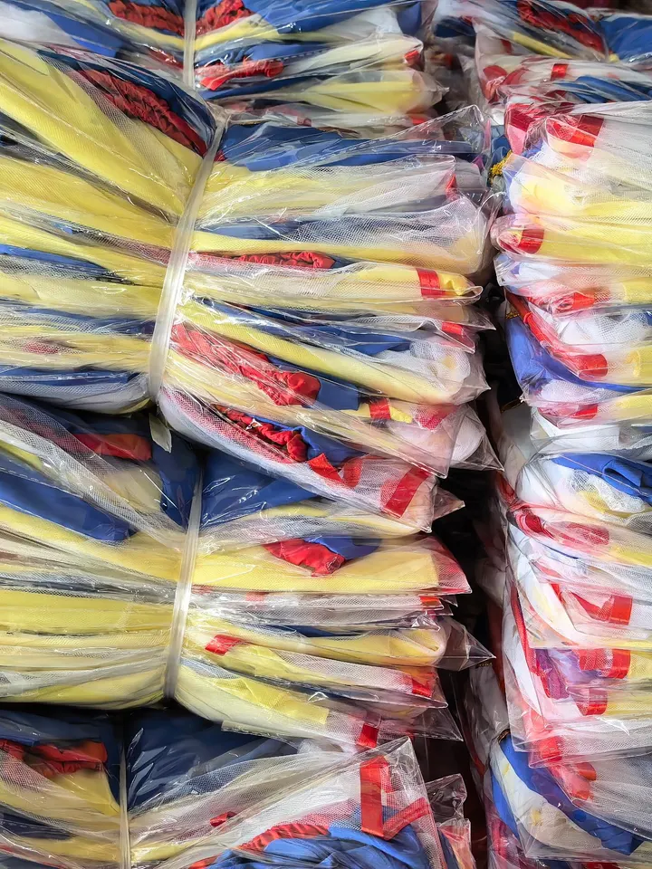 Ingepakte gele en blauwe verkleedjurken, gebundeld per maat